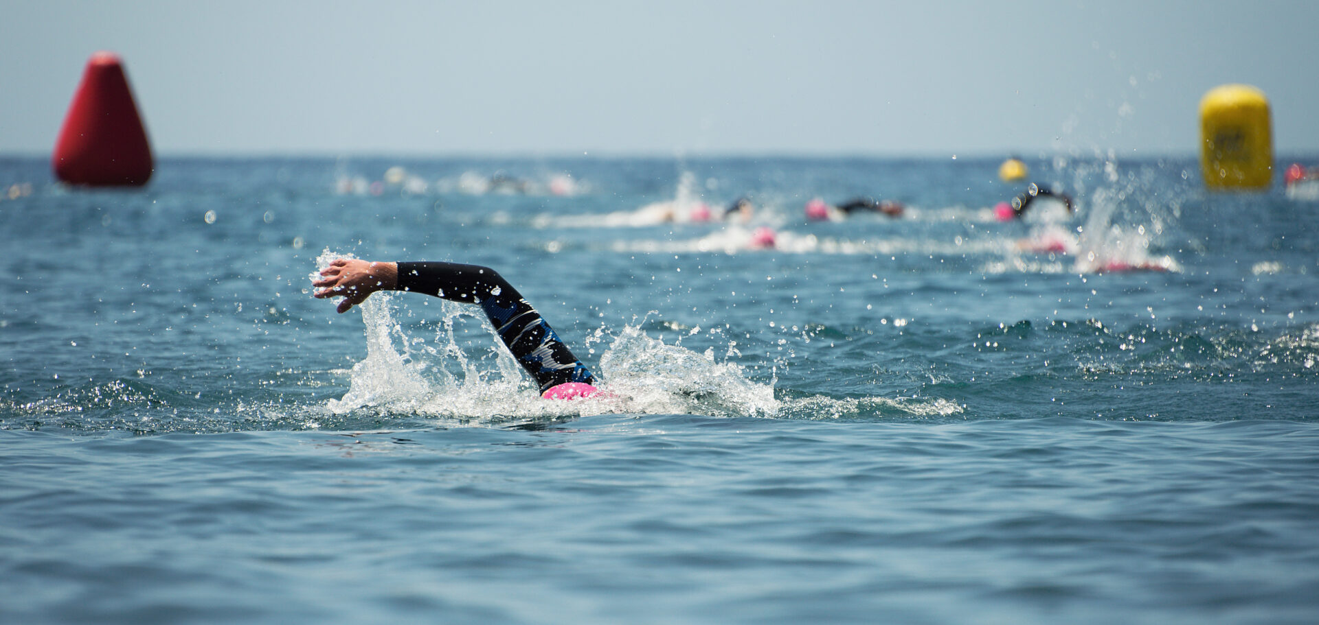 Group people in wetsuit swimming at triathlon